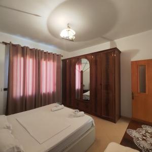 a bedroom with a bed and a large mirror at Bujari Guesthouse in Berat