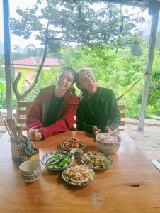 two people sitting at a table with plates of food at May Lai Homestay in Tả Van +61 photos