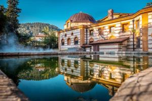 a building with a reflection in a body of water at Студио МИНЕРА in Kyustendil
