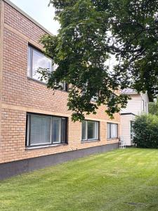 a brick building with a green lawn in front of it at Hamina Comfort Apartment in Hamina
