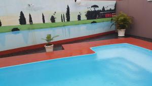 a blue swimming pool with a painting on the wall at Forest Hotel in Porto Velho