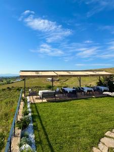 a picnic shelter with tables and benches in a field at Dione Bozcaada in Bozcaada