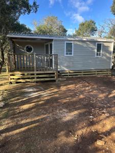a house with a porch with a fence at camping les dolmens in Méjannes-le-Clap