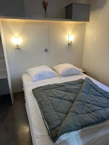 a bedroom with a large bed with two pillows at camping les dolmens in Méjannes-le-Clap