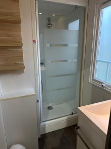a glass shower in a bathroom with a sink at camping les dolmens in Méjannes-le-Clap