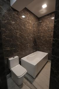 a bathroom with a toilet and a bath tub at Ritz The Boutique Hotel in Rohtak +30 photos
