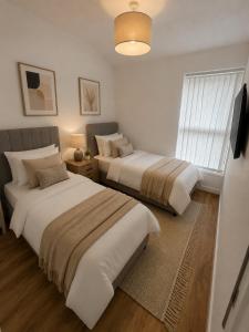 two beds in a bedroom with a window at Brennan stays contractor professional Friendly in Liverpool