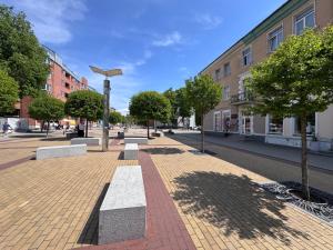 a park with a bench on a city street at Мazvydo Avenue Studio Кlaipeda City Centre in Klaipėda