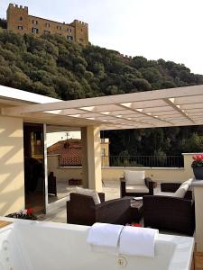 a patio with couches and chairs under a pergola at Hotel C'era Una Volta in Castiglione della Pescaia