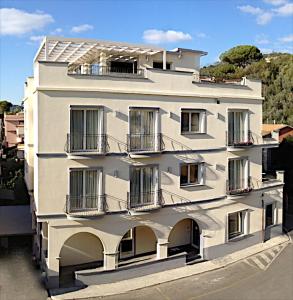 a white building with balconies on the side of it at Hotel C'era Una Volta in Castiglione della Pescaia