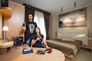 a man and a woman standing in a hotel room at Hotel C'era Una Volta in Castiglione della Pescaia