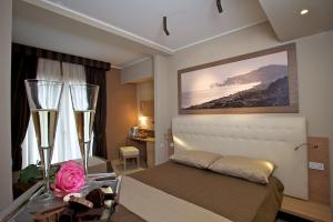 a bedroom with a bed with a flower on a table at Hotel C'era Una Volta in Castiglione della Pescaia