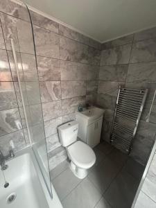 a bathroom with a toilet and a shower and a sink at Brennan stays contractor professional Friendly in Liverpool +3 photos