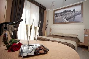 a hotel room with two beds and champagne glasses on a table at Hotel C'era Una Volta in Castiglione della Pescaia