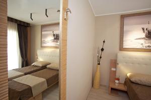 a bedroom with a bed and a mirror at Hotel C'era Una Volta in Castiglione della Pescaia