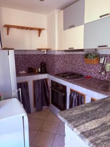 a kitchen with white cabinets and a stove top oven at La Terrazza in Civitavecchia +12 photos