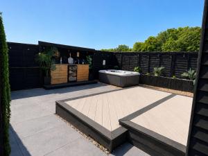 a patio with a hot tub and two benches at The Nest @The Outside Inn in Mountfield +11 photos