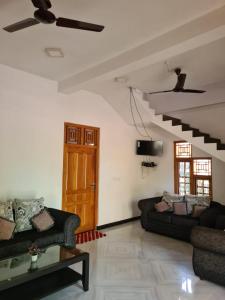 a living room with two couches and a staircase at Kanthans Lighthouse Cabanas in Komari