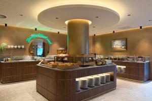 a bakery with a counter with food on it at TRYP Badhotel The Hague Scheveningen BRAND NEW in Scheveningen