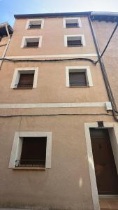 a tall brown building with windows and a door at Apartamentos TORRE DE LARA in Molina de Aragón