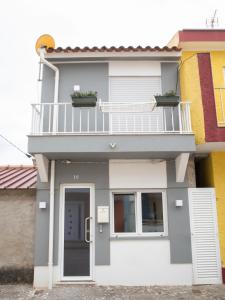 a house with a balcony on top of it at Casa 4 Peixes in Leiria