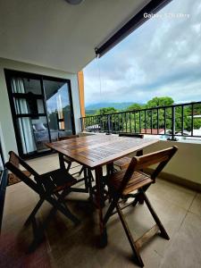 a wooden table and two chairs on a balcony at Cozy Melody in Pirae