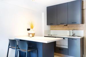 a kitchen with blue and white counters and chairs at Sör Apart Otel in Bodrum City