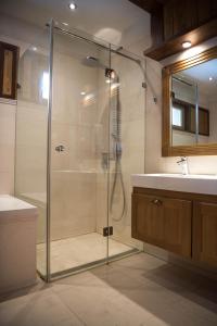y baño con ducha acristalada y lavamanos. en Villa Nataly at Golf Resort, en Bansko