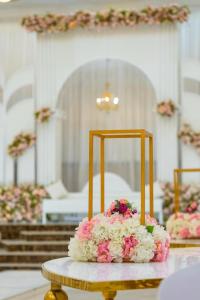 a cake sitting on top of a table with flowers at القاعة الملكية للافراح والموتمرات in Baţḩāʼ