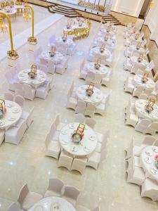 an overhead view of a banquet hall with white tables and chairs at القاعة الملكية للافراح والموتمرات in Baţḩāʼ