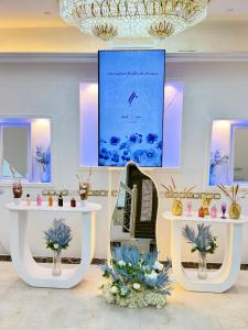 a room with a table with flowers and a picture at القاعة الملكية للافراح والموتمرات in Baţḩāʼ