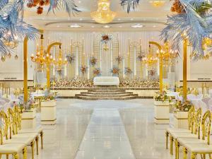 a banquet hall with white tables and chairs and chandeliers at القاعة الملكية للافراح والموتمرات in Baţḩāʼ