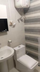 a bathroom with a white toilet and a sink at Galyat Apartments in Abbottabad