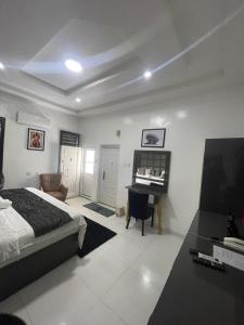 a bedroom with a bed and a desk and a piano at JRC Chariot Luxury Apartment in Omole