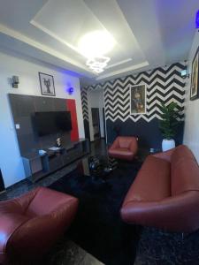 a living room with couches and a flat screen tv at JRC Chariot Luxury Apartment in Omole +11 photos