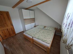 a small bedroom with a bed and a wooden floor at Apartmány Švec in Terchová