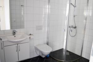 a bathroom with a toilet and a sink and a shower at Sula Rorbuer og Havhotell in Sula