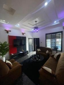 a living room with two couches and a tv at JRC Chariot Luxury Apartment in Omole