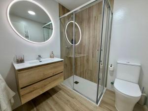 a bathroom with a toilet and a sink and a mirror at Apartamentos TORRE DE LARA in Molina de Aragón