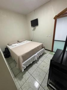 a bedroom with a bed and a flat screen tv at Quartus Hotel in Água Boa