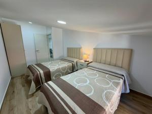 a bedroom with two beds and a mirror at Apartamentos TORRE DE LARA in Molina de Aragón