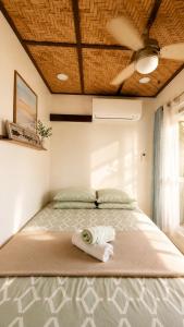 a bed with a towel on it in a room at Gloria's Home Stay in Oslob