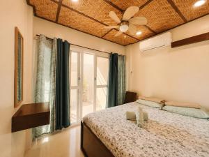 a bedroom with a bed and a ceiling fan at Gloria's Home Stay in Oslob +19 photos