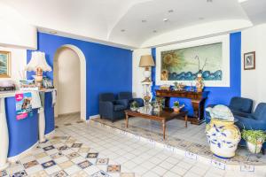 a living room with blue walls and a table and chairs at Hotel L'Approdo in Casamicciola Terme