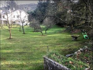 a park with a bench and a table in the grass at Casa con bosque en Cantabria in Ramales de la Victoria