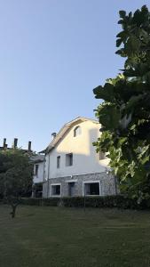 a large white building in a yard with a tree at Casa con bosque en Cantabria in Ramales de la Victoria