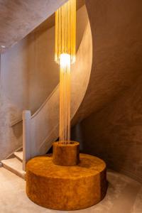 ein Tisch mit einer Lampe in einem Raum mit Treppe in der Unterkunft Hotel Cour Saint Georges by CW Hotel Collection in Gent + 52 Fotos