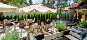 a patio with chairs and an umbrella and a hot tub at Apart kompleks Binis in Zlatibor