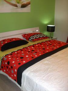 a bed with a red and black comforter and pillows at Rooms Bero in Senj
