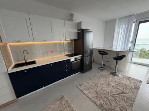 a kitchen with a sink and a black refrigerator at Blue luxury apartment Kune in Sakës